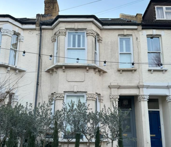 Pre restoration condition showing brickwork coated with textured paint